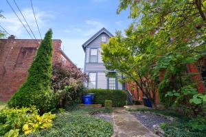 una casa blu con un cortile con cespugli di High Street Hideaway - For 8 a Milo