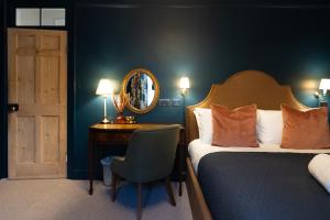 a bedroom with a bed and a desk and a mirror at Bishy Hill Town House in York in York