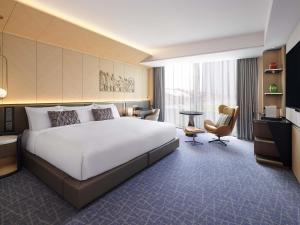 a hotel room with a large bed and a desk at Fairmont Ambassador Seoul in Seoul