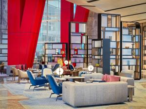 a lobby with couches and tables and red walls at Fairmont Ambassador Seoul in Seoul