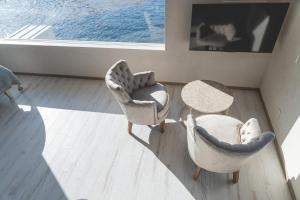 ein Wohnzimmer mit zwei Stühlen und einem Tisch in der Unterkunft COVE KAWANA - Vacation STAY 69198v in Kawana