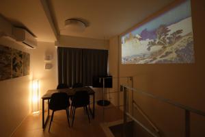 a dining room with a table and chairs and a painting at J-ARC Akebonobashi - Vacation STAY 17362 in Tokyo