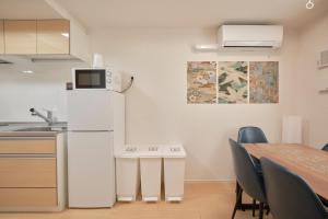 a kitchen with a refrigerator and a table with chairs at J-ARC Akebonobashi - Vacation STAY 17362 in Tokyo