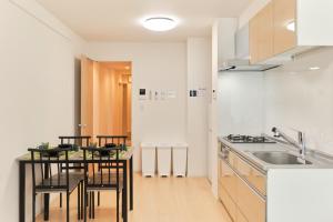 une cuisine avec une table, des chaises et un évier dans l'établissement J-ARC Akebonobashi - Vacation STAY 17363, à Tokyo 17 autres photos