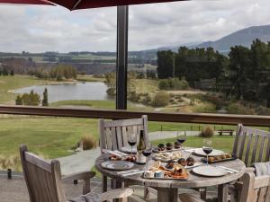 a table with food and wine glasses and a large window at Fable Terrace Downs Resort by MGallery in Windwhistle