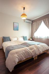 a large bed in a bedroom with a large window at Miyakojima - House - Vacation STAY 20446 in Hirara