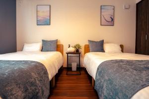 a room with two beds and a nightstand between them at Miyakojima - House - Vacation STAY 20446 in Hirara