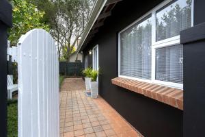 a house with a white fence and a window at Hilton House One in Hilton