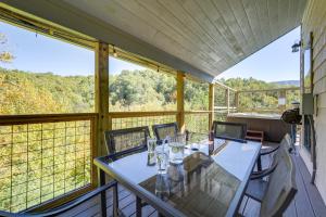 Un comedor con mesa y sillas en un balcón. en Game Room, Hot Tub, Pool and Views Gatlinburg Cabin, en Gatlinburg