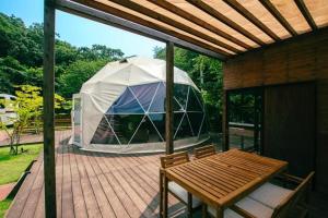ein Zelt auf einem Deck mit einem Holztisch in der Unterkunft Yura Green - Vacation STAY 73978v in Yura