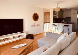 a living room with a couch and a flat screen tv at Loft Cosy sur le Lac in Bouveret