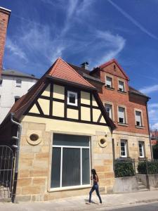 a woman walking down a street in front of a house at Villa Johner in Bayreuth