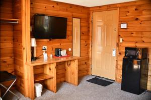 a room with a television and a wooden wall at Smith's Colonial Motel in Hancock