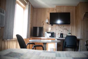 a kitchen with a table and chairs and a television at Smith's Colonial Motel in Hancock