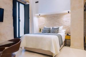a bedroom with a large bed with a brick wall at Luxurious studio with Jacuzzi in Casa Pilatos in Seville