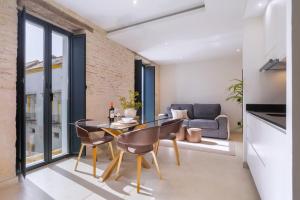 セビリアにあるLuxurious Duplex 2Bd 2Bth over Casa Pilatosのガラスのテーブルと椅子のあるリビングルーム
