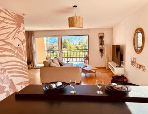a living room with a table with wine glasses on it at Loft Cosy sur le Lac in Bouveret