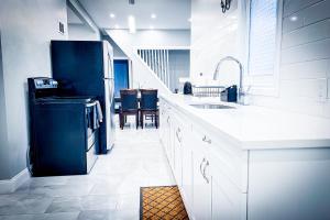 ナイアガラフォールズにあるPerfect 6BR Stay Near Niagara Falls & Attractionsのシンクと冷蔵庫を備えた白いキッチン