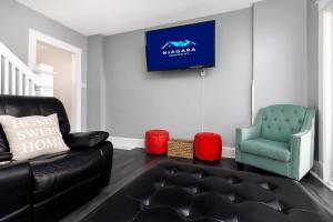 un salon avec un canapé en cuir noir et un fauteuil bleu dans l'établissement 3BR Gem Near Falls-Sleeps 6 Comfortably, à Niagara Falls 20 autres photos