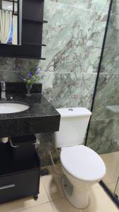 a bathroom with a white toilet and a sink at Flats containers in Rio Verde
