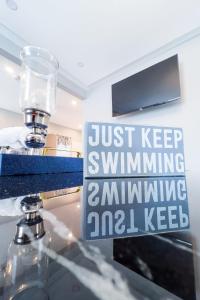 a sign that says just keep swimming swimmingamninkingamdcilcilcilcilcil at Group Friendly 6BR Near Aquarium & Niagara Falls in Niagara Falls