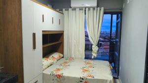 a small bedroom with a bed and a window at Flats containers in Rio Verde