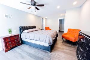 a bedroom with a bed and an orange chair at Group Friendly 6BR Near Aquarium & Niagara Falls in Niagara Falls
