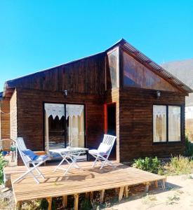 ein Haus mit zwei Stühlen und einem Tisch auf einer Terrasse in der Unterkunft Cabaña en Playa Totoralillo2 in Totoralillo