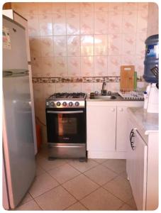 eine Küche mit einem Herd, einer Spüle und einem Kühlschrank in der Unterkunft Cabaña en Playa Totoralillo2 in Totoralillo