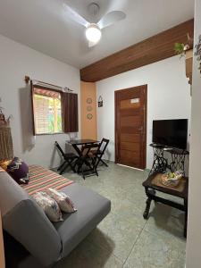 a living room with a couch and a table at Chales Canto dos Pássaros Boipeba in Cayru