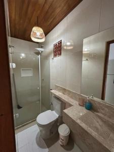 a bathroom with a toilet and a shower and a sink at Chales Canto dos Pássaros Boipeba in Cayru +60 photos