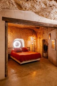a bedroom with a bed in a cave with a window at Le Cavernacle in Montrichard