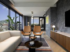 a living room with a couch and chairs and a tv at Mondrian Seoul Itaewon in Seoul