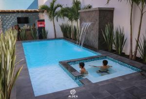 two people swimming in a swimming pool with a fountain at Aldea Express in San Juan Teotihuacán +54 photos