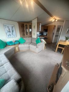 ein Wohnzimmer mit Sofa und Tisch in der Unterkunft Meadow view 93 8 berth Chapel, Skegness SANTANAVAN 15 in Chapel Saint Leonards