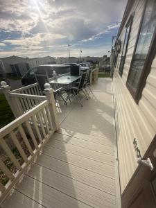 eine Terrasse mit einem Tisch und Stühlen auf einem Haus in der Unterkunft Meadow view 93 8 berth Chapel, Skegness SANTANAVAN 15 in Chapel Saint Leonards
