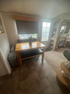 ein Wohnzimmer mit einem Tisch und einer Pflanze darauf in der Unterkunft Meadow view 93 8 berth Chapel, Skegness SANTANAVAN 15 in Chapel Saint Leonards