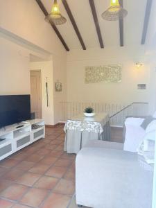 a living room with a table and a tv at Casa Rural Arrebol - Barbacoa y piscina in Aracena