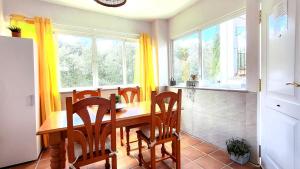 a dining room with a table and chairs and windows at Casa Rural Arrebol - Barbacoa y piscina in Aracena