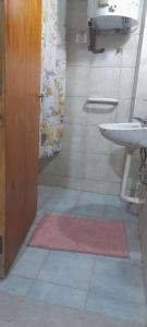 a bathroom with a sink and a bathroom door at Kallpa in Tinogasta