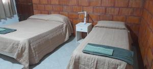 a room with two beds and a table with a lamp at Kallpa in Tinogasta
