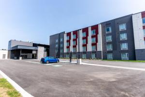 a blue car parked in a parking lot in front of a building at Holiday Inn Express & Suites - Trois Rivieres Ouest by IHG in Trois-Rivières