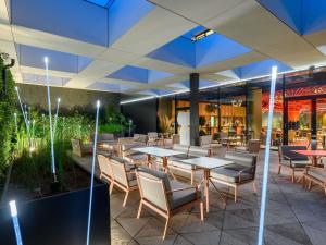 a restaurant with tables and chairs in a building at Mercure Debrecen in Debrecen
