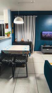 a dining room with a table and a tv at Lindo Apartamento em João pessoa com ar condicionado in João Pessoa