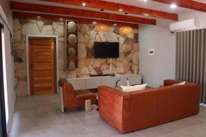 a living room with a couch and a tv on a stone wall at Makonde river lodge in Makonde