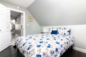 a bedroom with a bed with a blue and white comforter at Cozy Micro apartment, Minutes from Falls in Niagara Falls