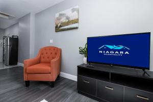a living room with a television and a chair at Cozy Micro apartment, Minutes from Falls in Niagara Falls