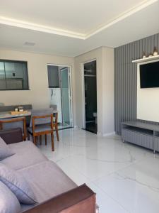 un soggiorno con un divano e una televisione di Residencial DX a Guarapuava