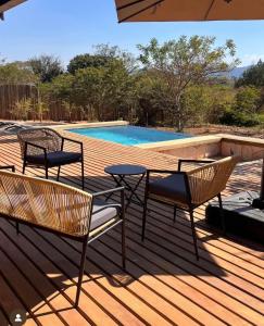 a deck with two chairs and a table and a pool at Makonde river lodge in Makonde