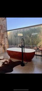 a red bath tub in a bathroom with a window at Makonde river lodge in Makonde